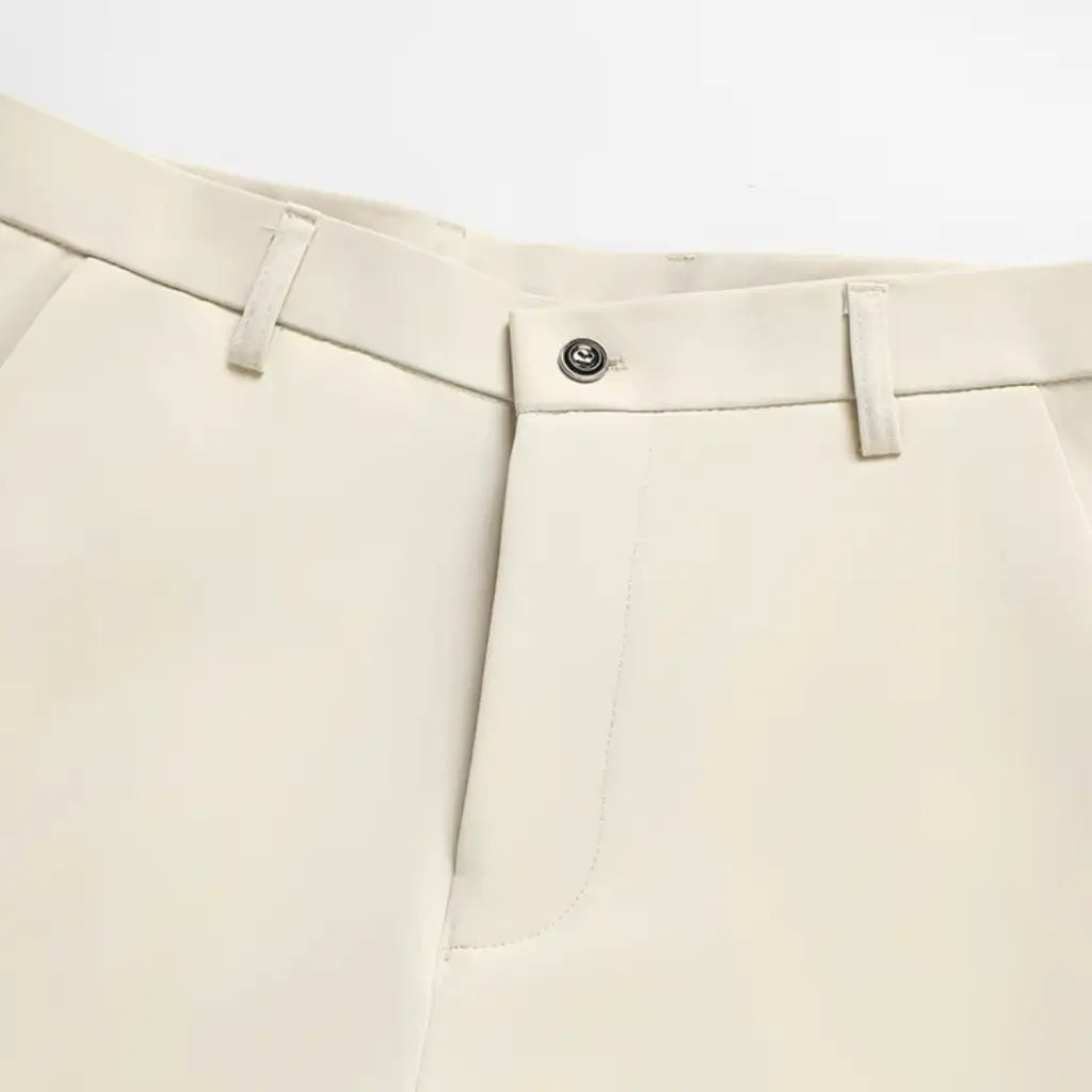 Vista superior da calça slim bege com botão e passantes para cinto.