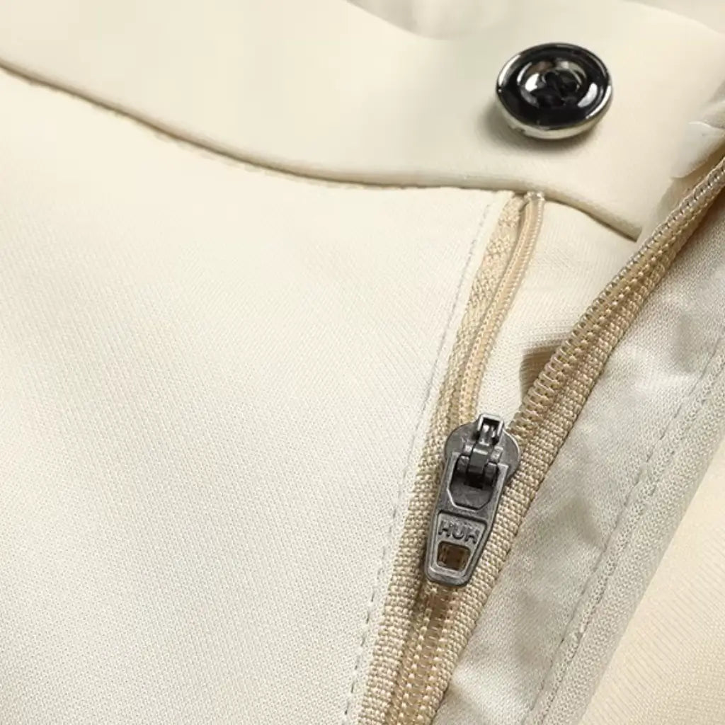 Detalhe do zíper metálico da calça social masculina slim bege.