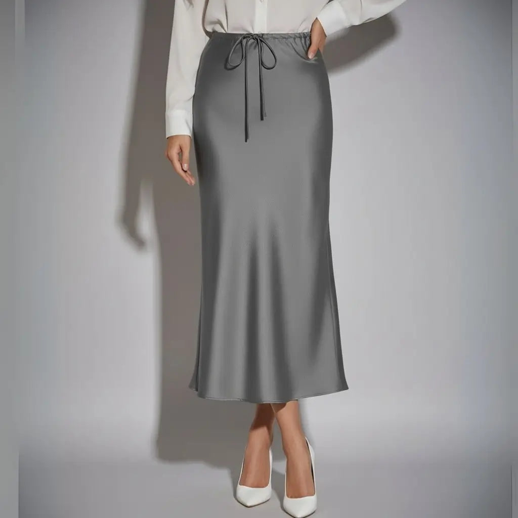 Saia longa feminina de cetim cinza com cintura ajustável e caimento reto, ideal para looks elegantes e versáteis do dia à noite