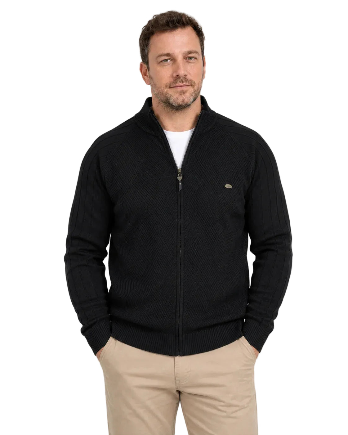 Homem de frente usando suéter preto com zíper frontal inteiro, gola alta e camiseta branca aparecendo no decote. A peça tem trama geométrica no peito, mangas caneladas e barra ajustada, combinada com calça bege.