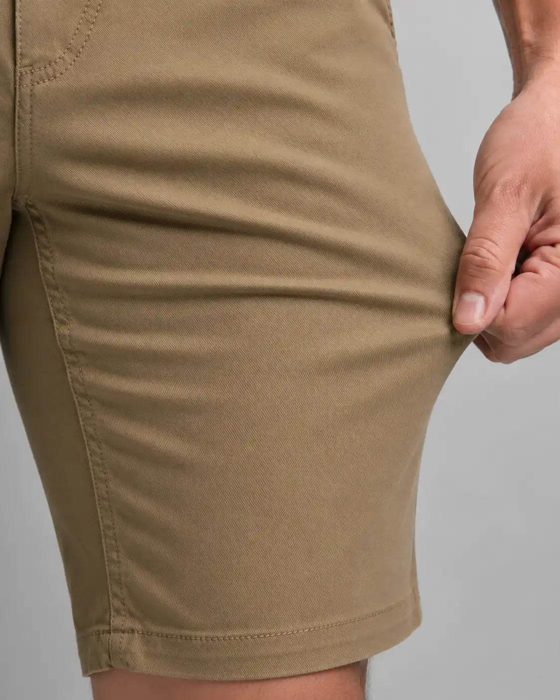 Bermuda Masculina em Sarja Valori Caqui, vista de frente em detalhe no corpo em fundo branco.