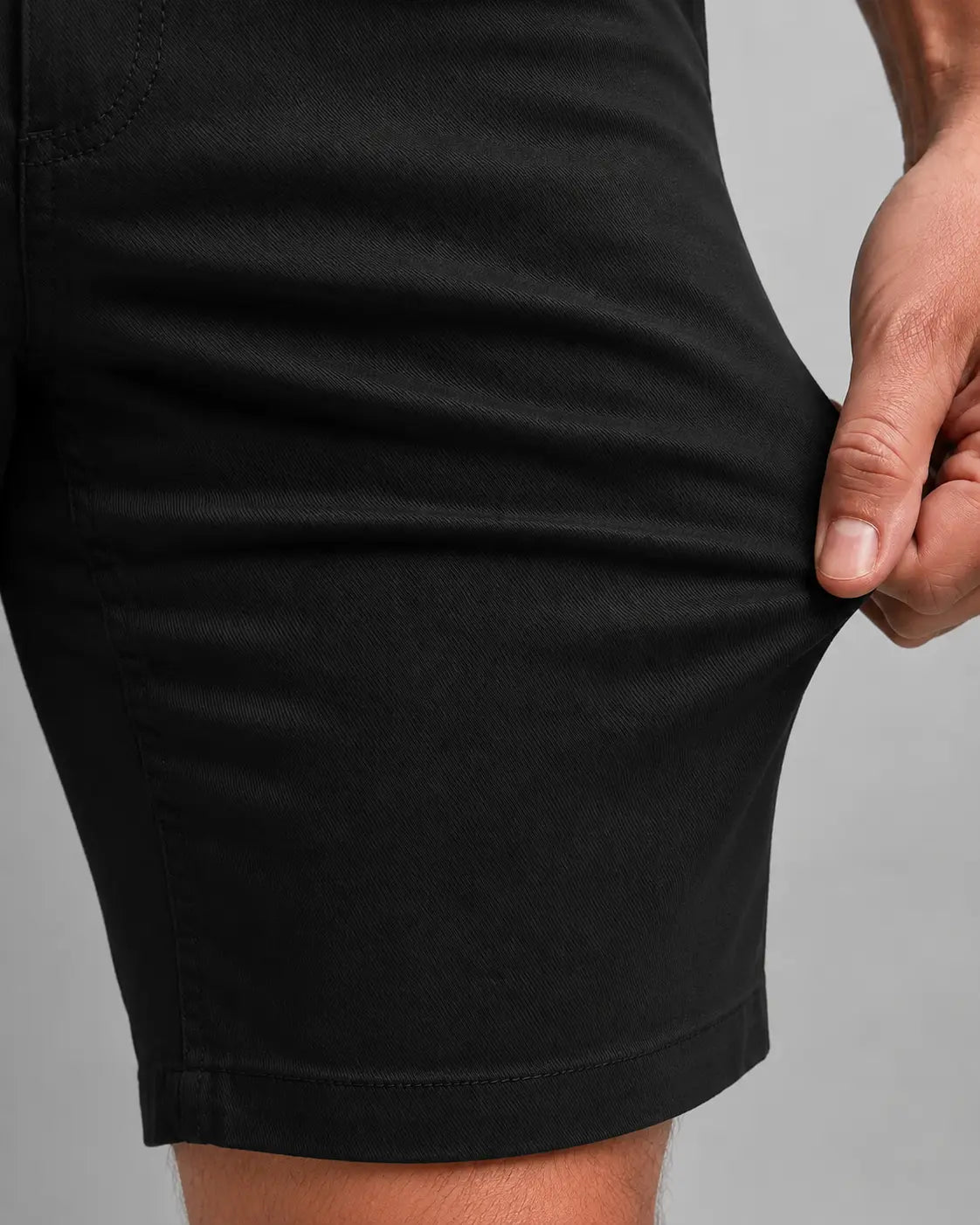 Bermuda Masculina em Sarja Valori Preta, vista de frente em detalhe no corpo em fundo branco.