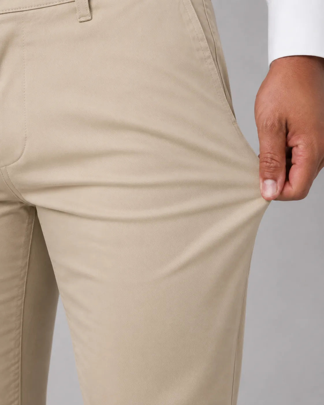 Calca Masculina em Sarja Valori Bege, vista de frente em detalhe no corpo em fundo branco.