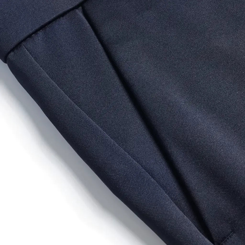 Detalhe lateral da calça azul marinho mostrando costura precisa e bolso discreto