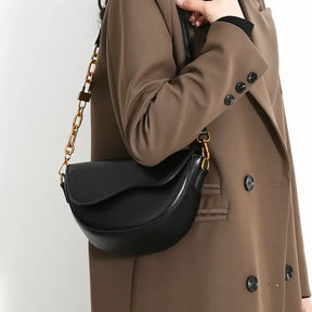 Vista lateral da Bolsa Amélie preta com estrutura curvada e fechamento elegante