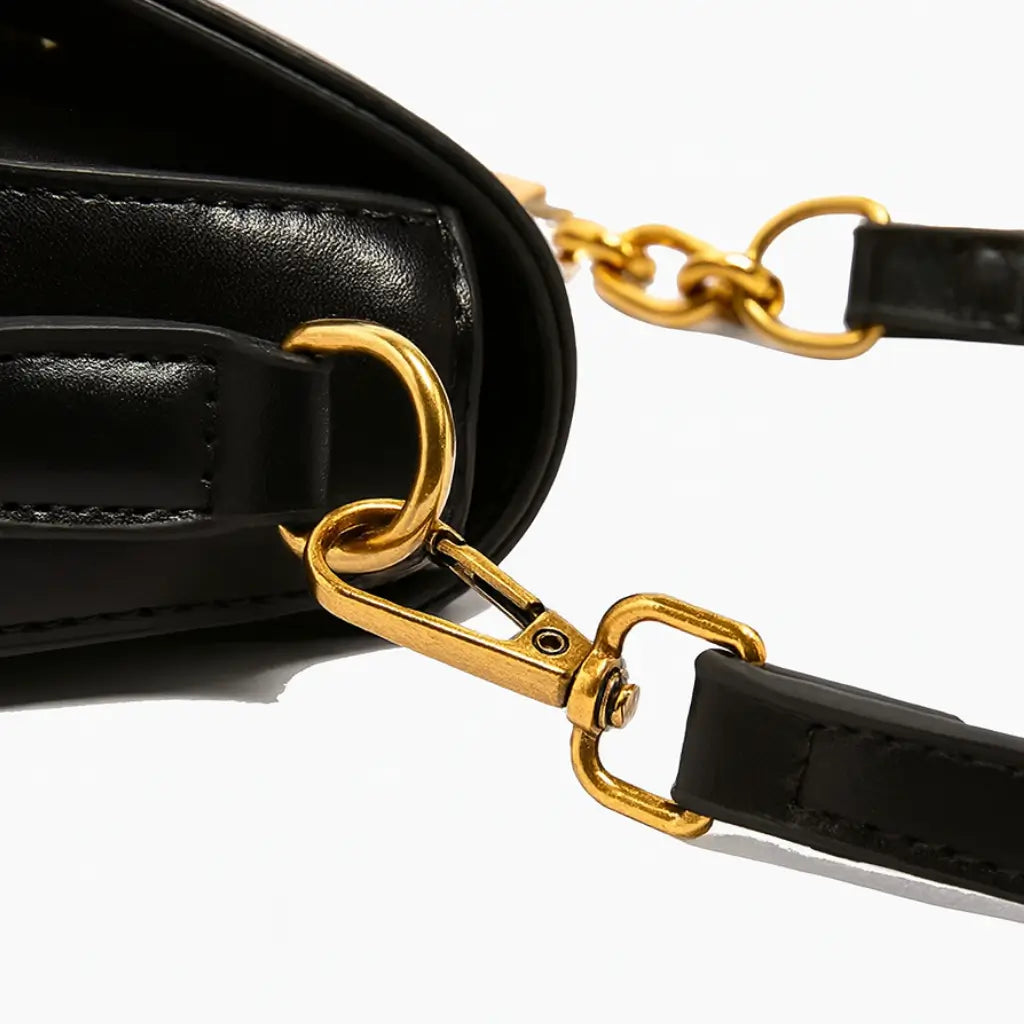Detalhe da alça dourada da Bolsa Amélie preta, design refinado