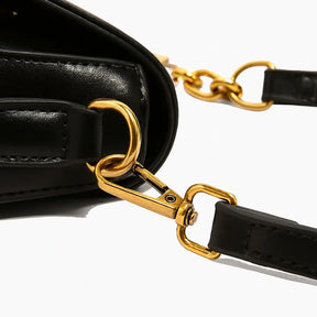 Detalhe da alça dourada da Bolsa Amélie preta, design refinado
