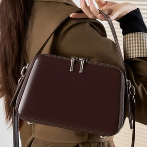Mulher segurando bolsa caramelo