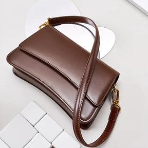 bolsa feminina marrom de couro estruturado com alça e fivela dourada