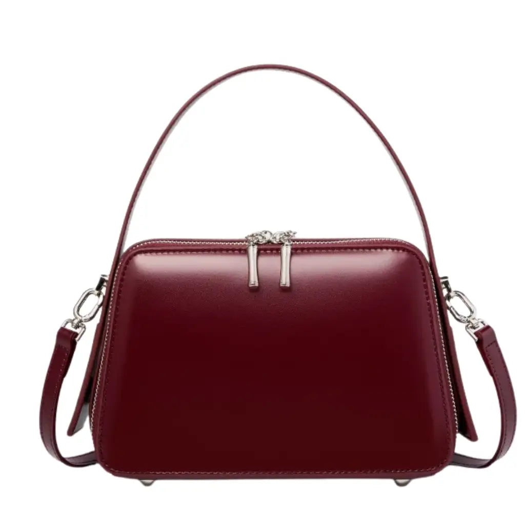 Bolsa feminina estruturada AVONNUE em tom vinho, alça de mão e fecho superior prateado em design sofisticado.
