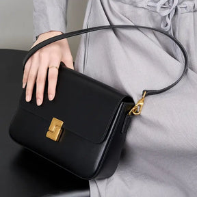 Bolsa feminina preta em couro legítimo com fecho dourado e alça longa