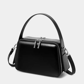 Bolsa feminina preta em couro legítimo com estrutura reta e alça curta 