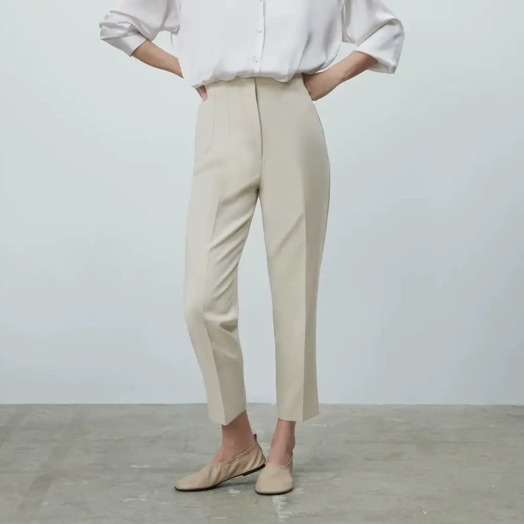 Modelo vestindo a Calça Social Feminina Bege Modelo Milano com camisa branca e sapato nude, visual elegante e moderno