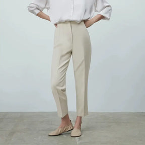 Modelo vestindo a Calça Social Feminina Bege Modelo Milano com camisa branca e sapato nude, visual elegante e moderno