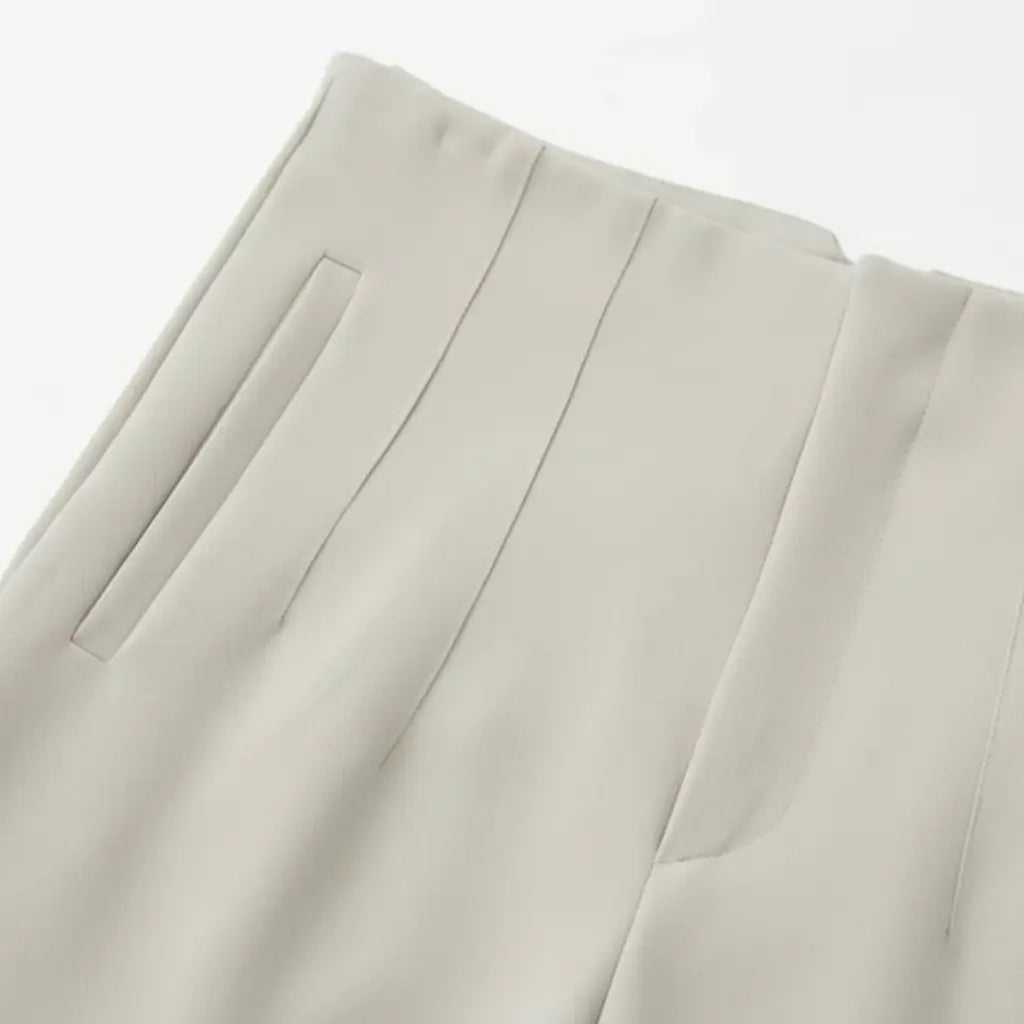 Close-up da cintura e bolso frontal da Calça Milano Bege, mostrando costura refinada e alfaiataria premium.