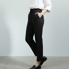 Calça social preta feminina com cintura alta e modelagem reta, vista lateral com camisa branca