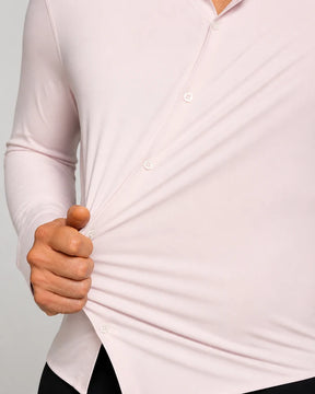 Close-up de homem vestindo a Camisa Social Masculina Tech Matteo Rosa e puxando o tecido na lateral, mostrando sua elasticidade e flexibilidade.