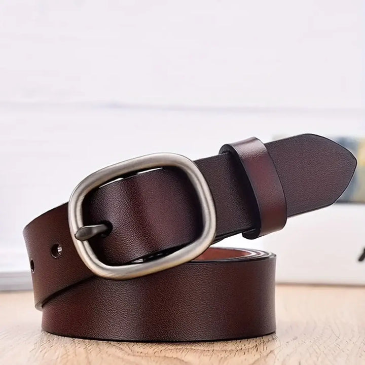 Cinto de couro marrom enrolado com textura natural e fivela oval estruturada.
