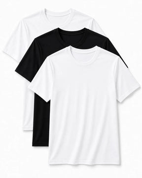 Três camisetas masculinas básicas sobrepostas em fundo claro, sendo duas brancas e uma preta ao fundo, com gola redonda e mangas curtas, organizadas em leve diagonal para apresentar o kit.