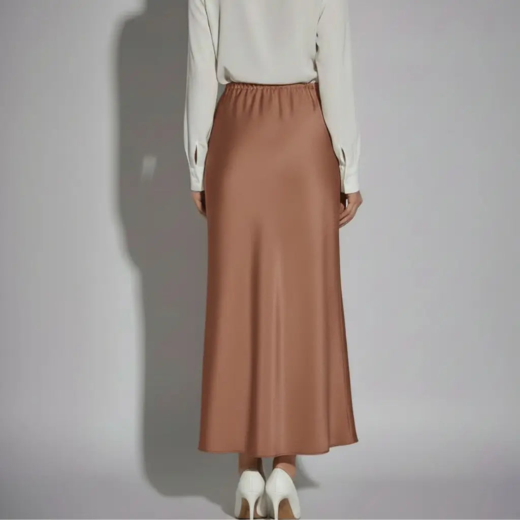 Vista traseira de saia longa em cetim chocolate com cós elástico e corte reto, une conforto e elegância para o guarda-roupa feminino