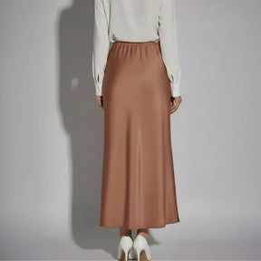 Vista traseira de saia longa em cetim chocolate com cós elástico e corte reto, une conforto e elegância para o guarda-roupa feminino