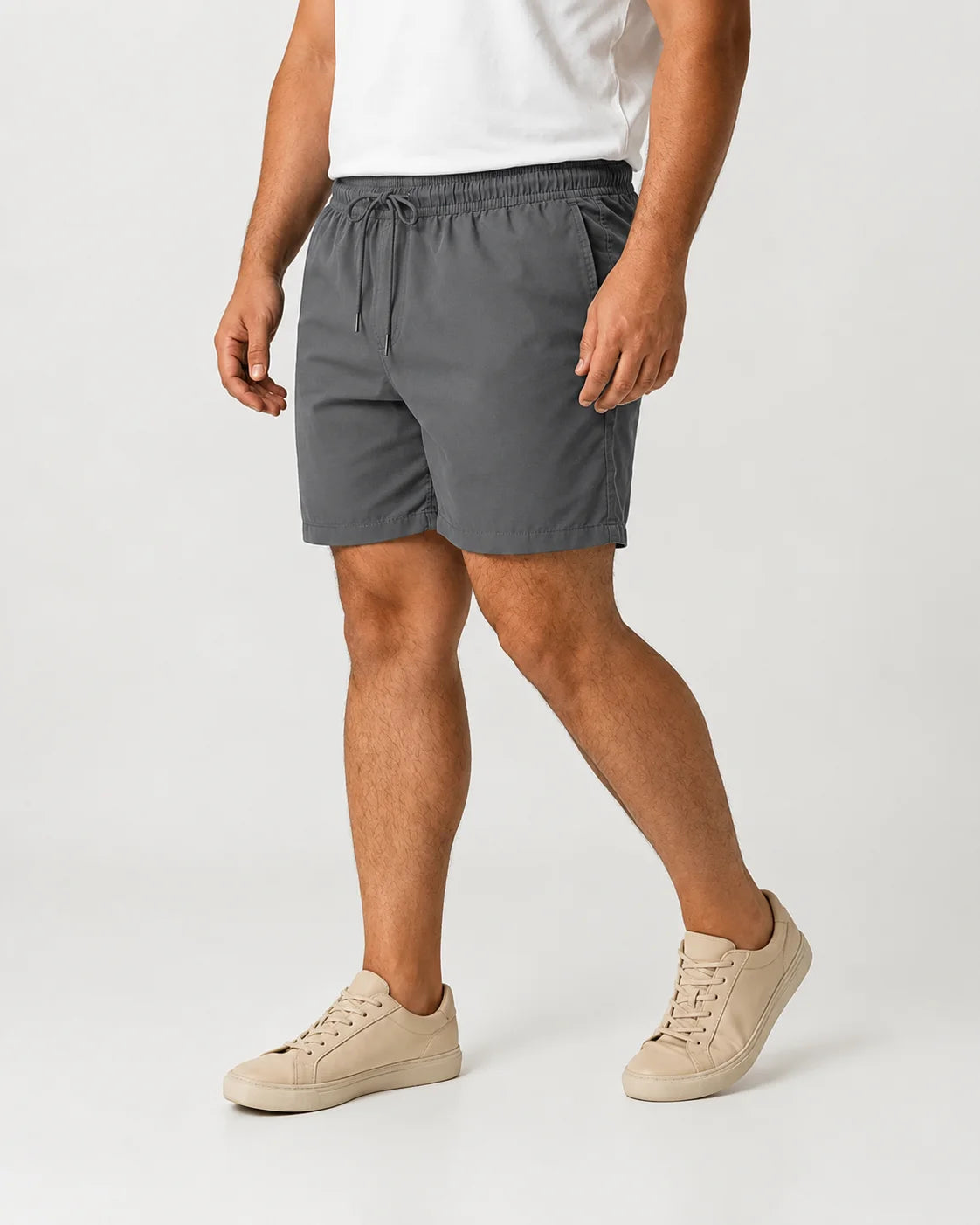 Homem usando o Short Masculino MareVitto Cinza com camiseta branca e tênis bege, em vista três quartos, sobre fundo claro de estúdio.