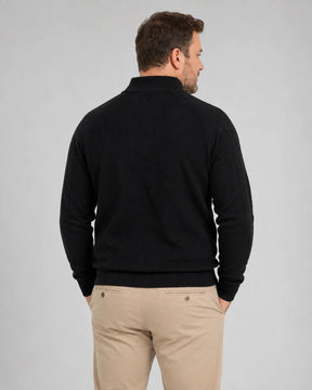 Homem de costas usando suéter preto com gola alta, mangas longas caneladas e barra ajustada na cintura. A parte traseira apresenta textura discreta em linhas diagonais e caimento confortável sobre a calça bege.