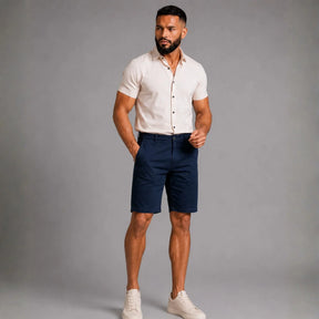 Homem vestindo bermuda masculina em sarja azul marinho AVONNUE de frente
