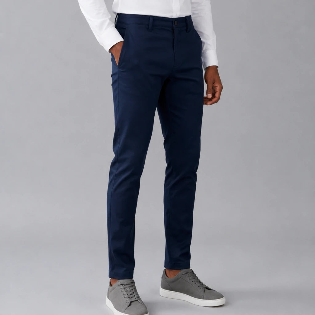 Homem vestindo calça masculina em sarja azul marinho com camisa branca e tênis casual