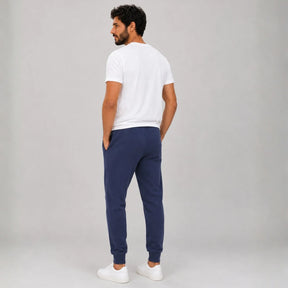 Calça de moletom masculina azul marinho vista de costas mostrando bolsos e punhos na barra