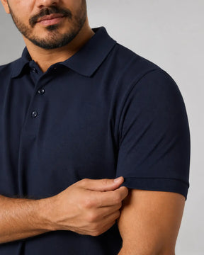 Camisa Polo Masculina PimaSenso Azul Marinho, detalhe da manga e caimento no corpo em fundo branco.