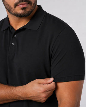Camisa Polo Masculina PimaSenso Preta, detalhe da manga e caimento no corpo em fundo branco.