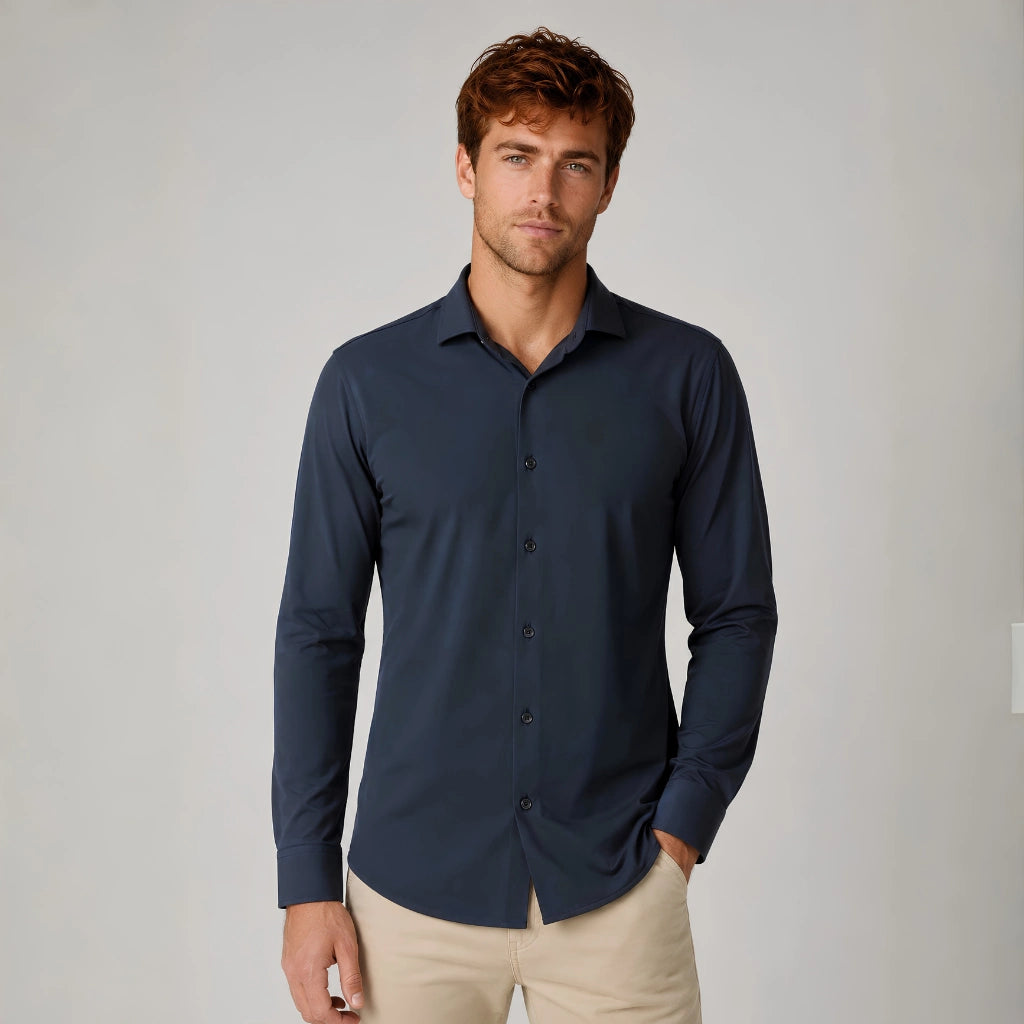 Homem vestindo camisa social masculina tech stretch azul marinho com calça bege, vista de frente.