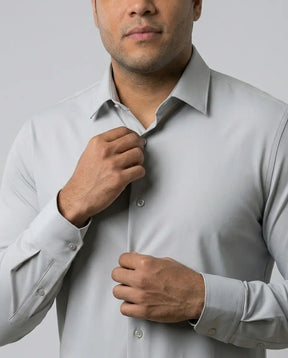 Close de homem ajustando a gola da Camisa Social Tech Vitto cinza-claro, com destaque para os botões, os punhos e o tecido liso.