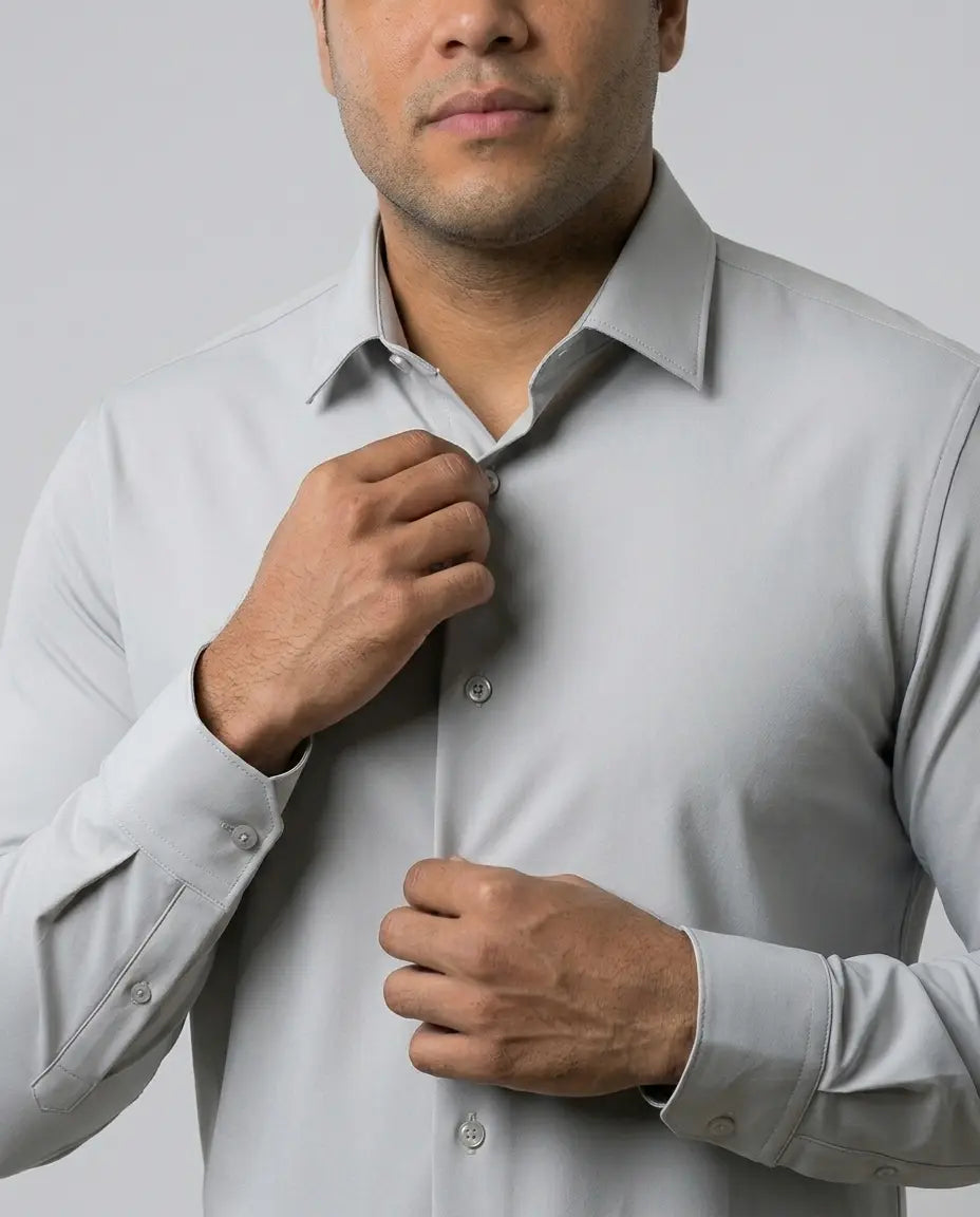 Close de homem ajustando a gola da Camisa Social Tech Vitto cinza-claro, com destaque para os botões, os punhos e o tecido liso.