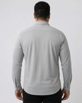 Homem de costas vestindo a Camisa Social Tech Vitto cinza-claro, mostrando o caimento nas costas, as mangas longas e a barra arredondada.