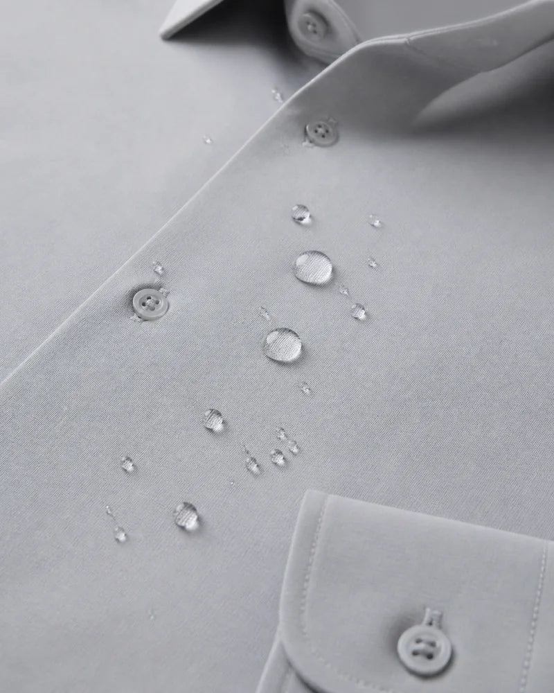 Close da Camisa Social Tech Vitto cinza-claro com gotas de água sobre o tecido, mostrando a gola, os botões e parte do punho.