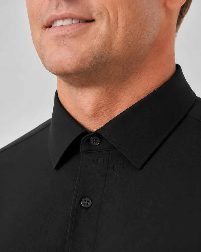 Close de homem vestindo a Camisa Social Tech Vitto preta com a gola fechada, mostrando o botão superior e o acabamento frontal.