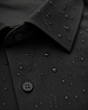Close da Camisa Social Tech Vitto preta com gotas de água sobre o tecido, mostrando a gola, os botões e as costuras.