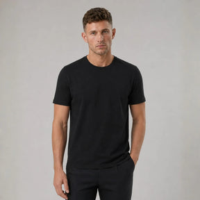 Homem vestindo camiseta masculina preta de algodão egípcio, de frente, com uma mão no bolso