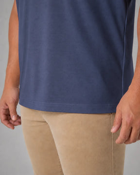 Detalhe da barra da camiseta masculina TechModal azul-marinho, com acabamento limpo e tecido de aparência suave.