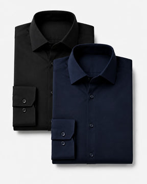 Kit com duas camisas sociais masculinas TechVitto dobradas sobre fundo branco, sendo uma preta posicionada atrás e uma azul-marinho à frente. As duas têm manga longa, gola estruturada, botões escuros e punhos visíveis.